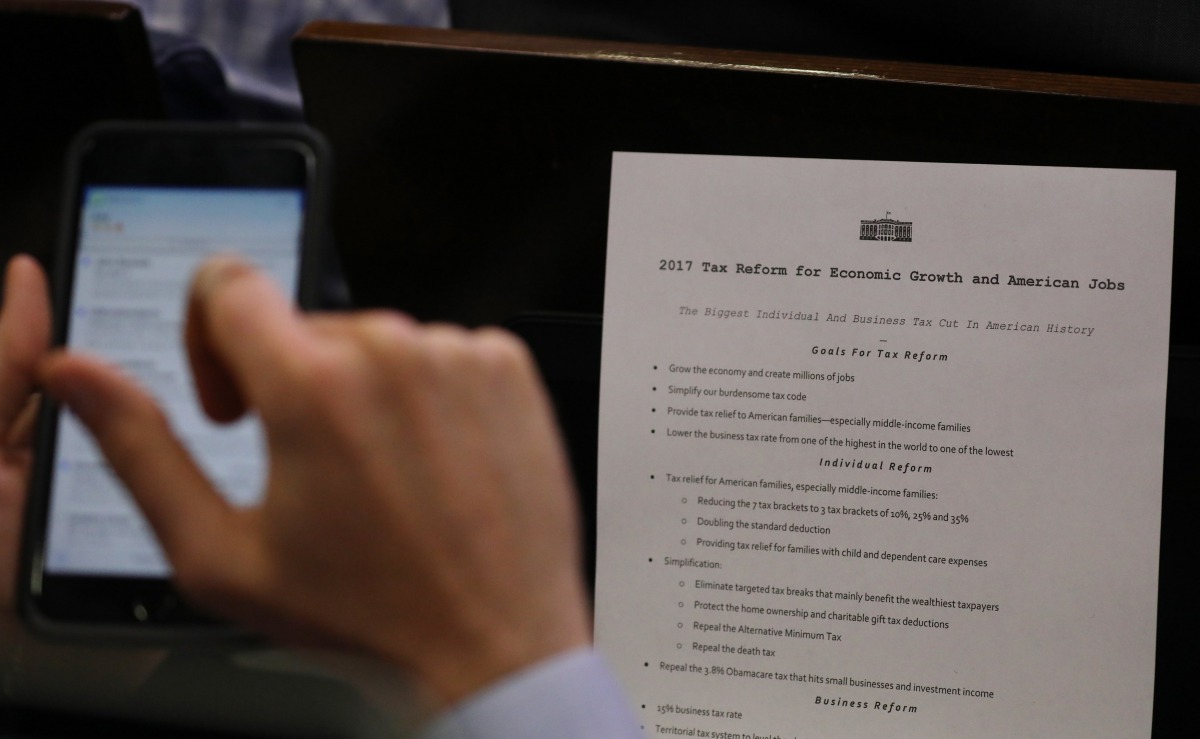 A reporter shoots a picture of a White House press release on its tax reform plan during the daily briefing at the White House in Washington, U.S., April 26, 2017. REUTERS/Carlos Barria