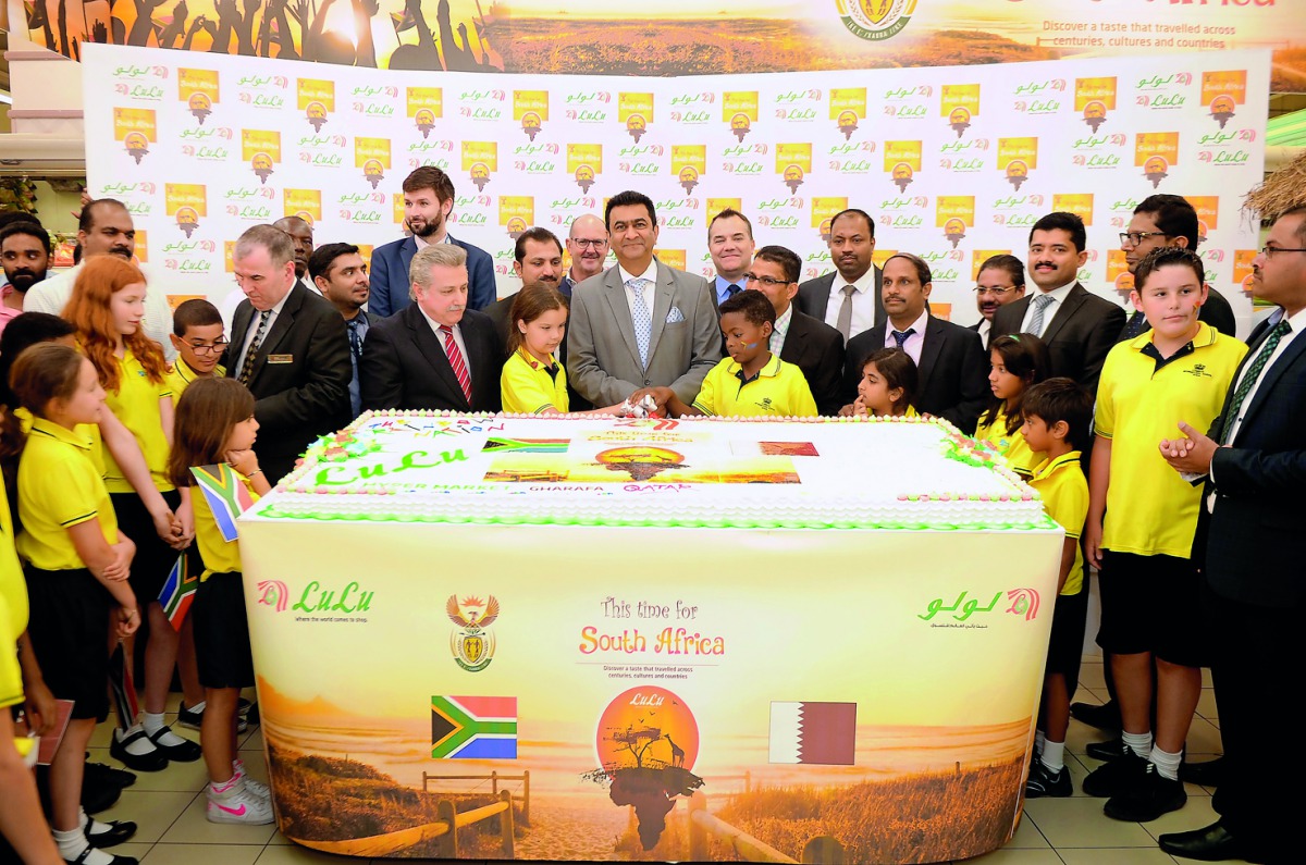 Prof. Shirish Soni (centre), Ambassador of South Africa to Qatar, cutting a cake with South African students and officials of Lulu Group at the opening of South African Food Festival at Lulu Hypermarket in Al Gharrafa, yesterday. Pic: Abdul Basit / The Pe