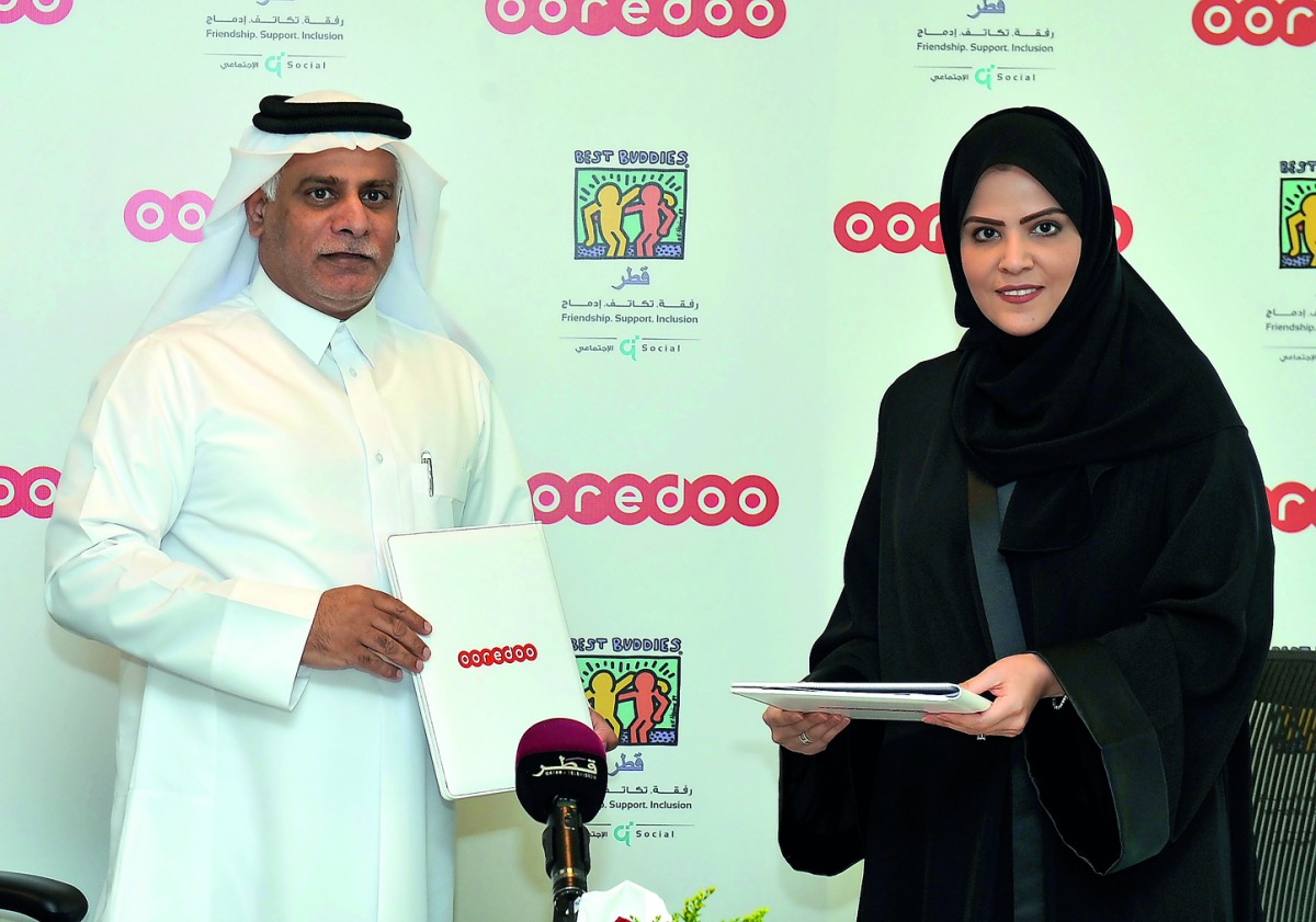 Chief Operating Officer of Ooredoo, Yousuf Abdulla Al Kubaisi (left), exchanges documents with Executive Director of Best Buddies Qatar, Laalei Abu Alfain, after the signing ceremony at Ooredoo Headquarters yesterday. 
Pic: Kammutty VP / The Peninsula