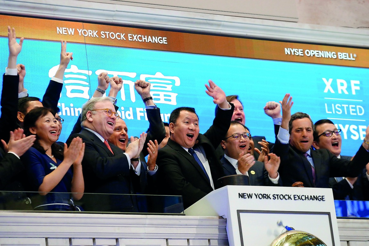 Zhengyu Wang (centre), CEO of China Rapid Finance Ltd., rings the opening bell with company executives and guests to celebrate the company's IPO at the New York Stock Exchange (NYSE) in New York, US.