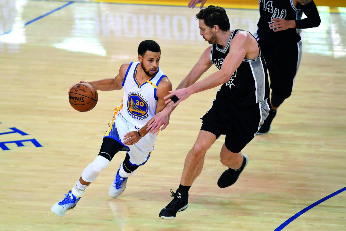 Stephen Curry (30) of the Golden State Warriors drives with the ball against Pau Gasol of the San Antonio Spurs during Game Two of the NBA Western Conference Finals at Oracle Arena in Oakland, California on Tuesday.