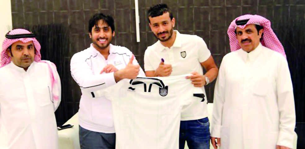 Qatari international defender Khoukhi Boualem (third left) poses for a photograph, holding the Al Sadd jersey with club officials after signing a two-year deal with the Emir Cup champions on Monday.  LEFT: Al Sadd's Algerian striker Baghdad Bounedjah sign