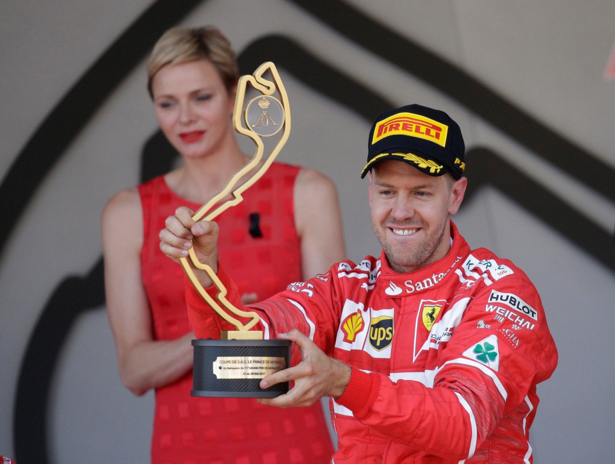 7Ferrari’s Sebastian Vettel celebrates winning the race on the podium with the trophy. (Reuters / Max Rossi)