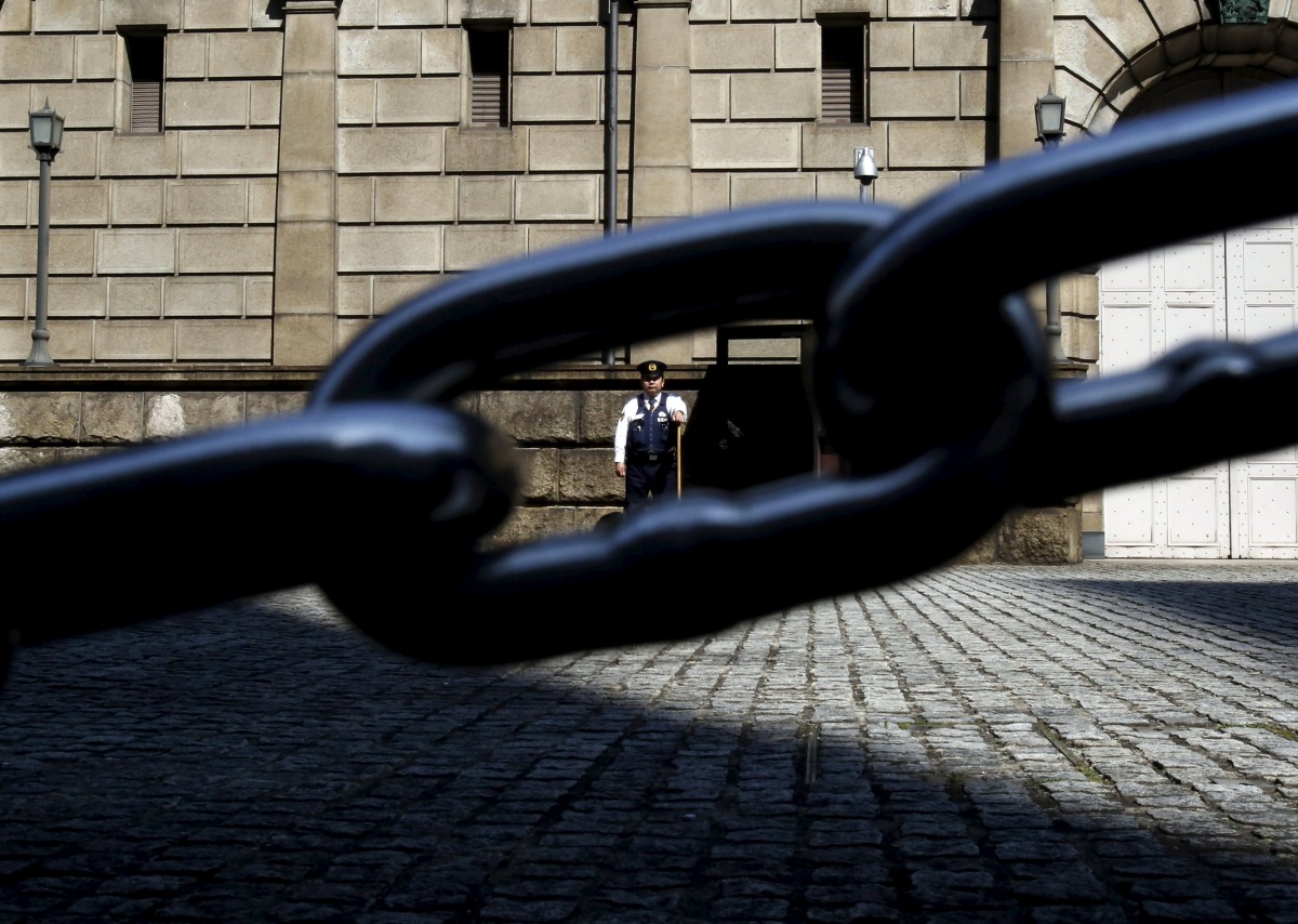 A security officer is seen through a chain link as he stands guard outside the Bank of Japan headquarters in Tokyo, March 31, 2016( REUTERS / Yuya Shino) 