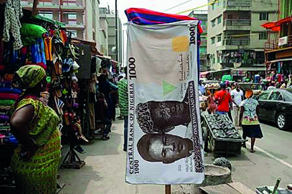 A towel with a print of the Nigerian naira is displayed for sale at a street market in the central business district in Nigeria