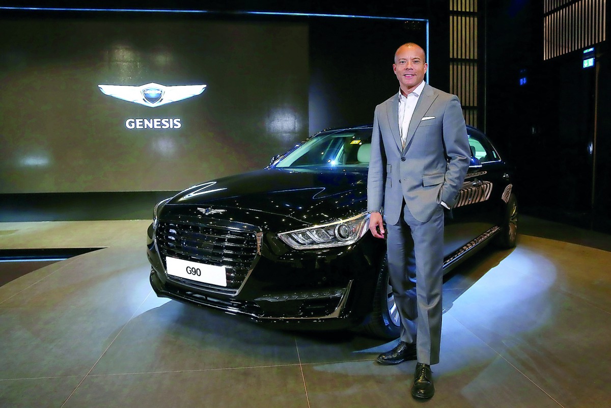A senior official of the company poses for a photo with the Genesis G90.