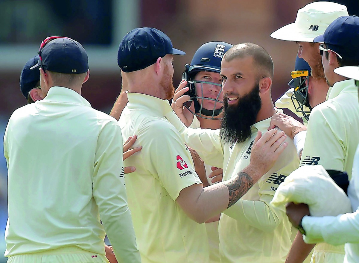 England's Moeen Ali (right) celebrates the wicket of South Africa's JP Duminy with team-mates during the fourth day of the first Test match at Lord's Cricket Ground in central London, yesterday.