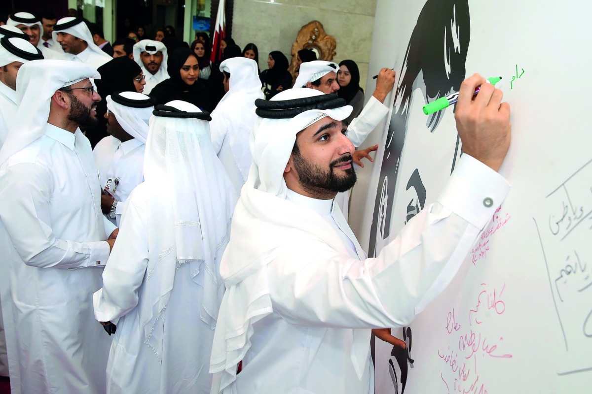 Qatar Football Association (QFA) Secretary General Mansoor Al Ansari signing a poster of the Emir H H Sheikh Tamim bin Hamad Al Thani at Al Bidda Tower yesterday. QFA representatives and office-bearers yesterday gathered around to sign the huge poster in 