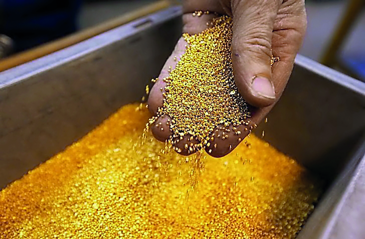 A worker checks gold granulate at a plant of gold refiner and bar manufacturer Valcambi SA in the southern Swiss town of Balerna.