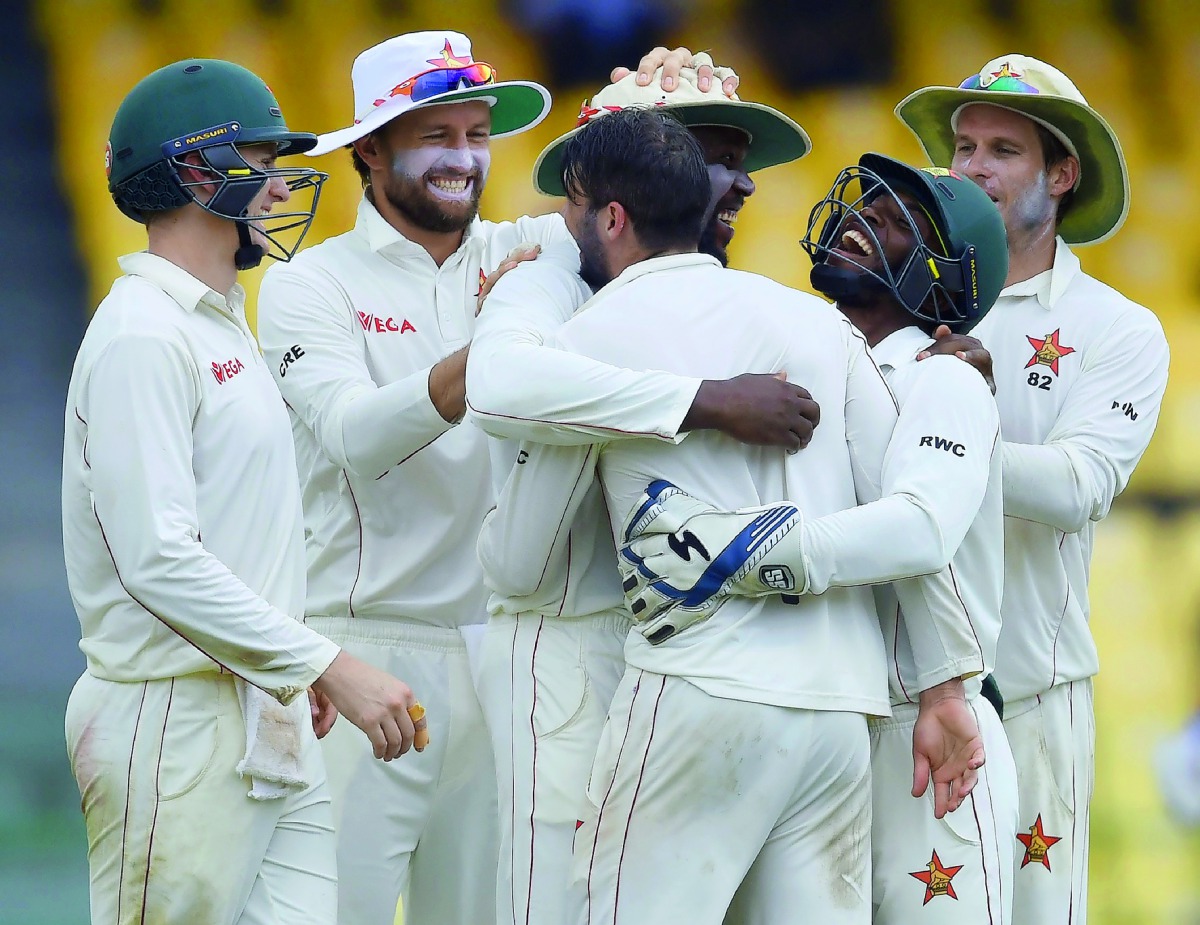 Zimbabwe cricketer Hamilton Masakadza (third left) celebrates with after dismissing Sri Lankan captain Dinesh Chandimal during the fourth day of a one-off Test match at the R Premadasa Cricket Stadium in Colombo.