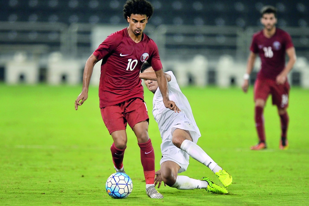 Qatar’s Akram Afif (left) vies for the ball possession with a Turkmenistan player during their 2018 AFC U-23 Championship Group C qualifier at  Al Sadd Stadium yesterday. Qatar beat Turkmenistan 2-0. Picture by Kammutty VP /  The Peninsula