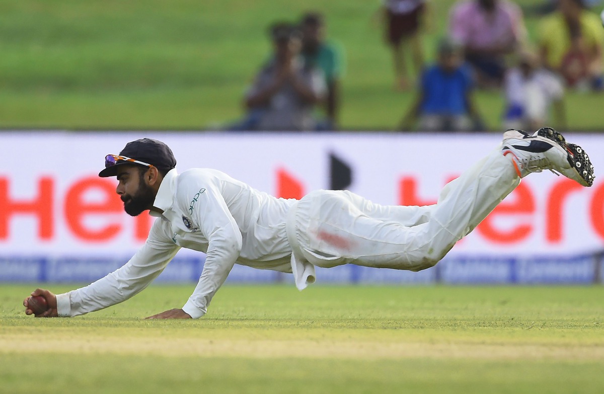 Indian cricket team captain Virat Kohli catches a ball during the second day of the first Test match between Sri Lanka and India at Galle International Cricket Stadium in Galle on July 27, 2017. / AFP / ISHARA S. KODIKARA