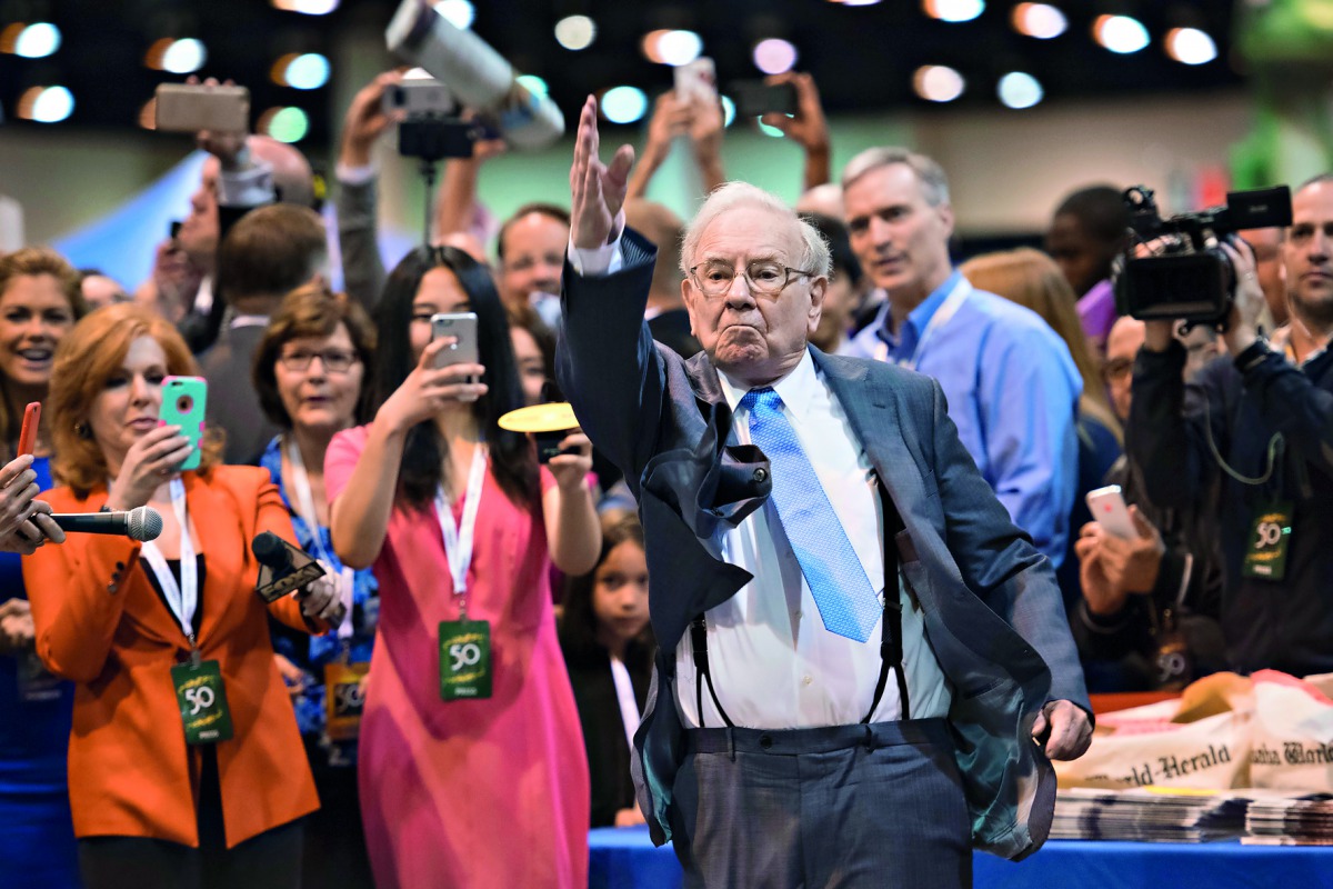 Warren Buffett tossing a newspaper at the Berkshire Hathaway annual shareholders meeting in Omaha in 2015 