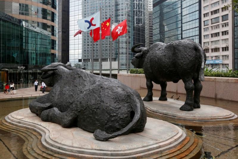 FILE PHOTO: (L-R) The Hong Kong Exchanges flag, Chinese national flag and Hong Kong flag are hoisted outside the Hong Kong Stocks Exchange in Hong Kong June 7, 2016. Reuters/Bobby Yip