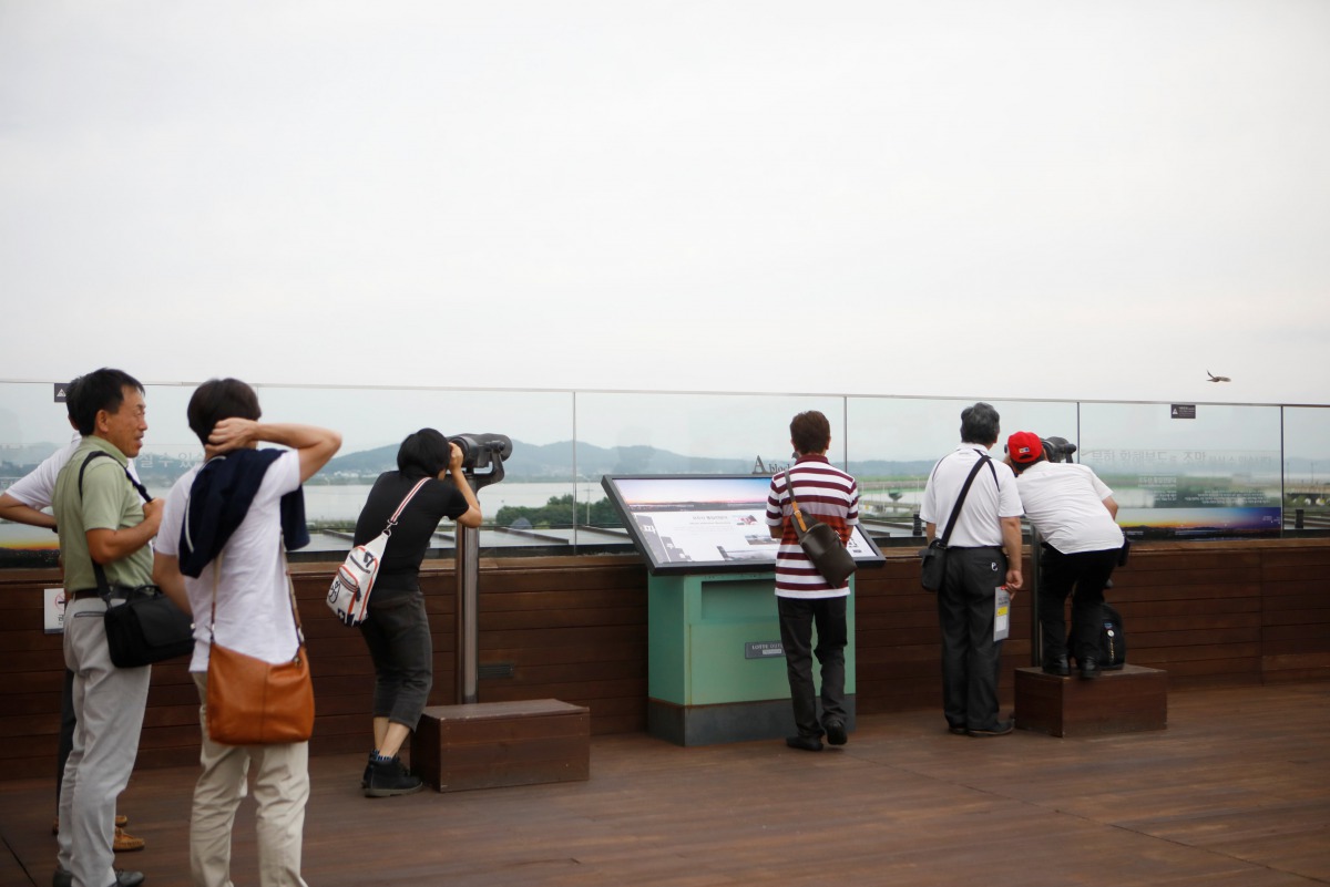 FILE PHOTO: Visitors look toward a North Korean village through a pair of binoculars at a shopping mall near the demilitarized zone separating the two Koreas in Paju, July 16, 2017 (REUTERS / Kim Hong-Ji) 