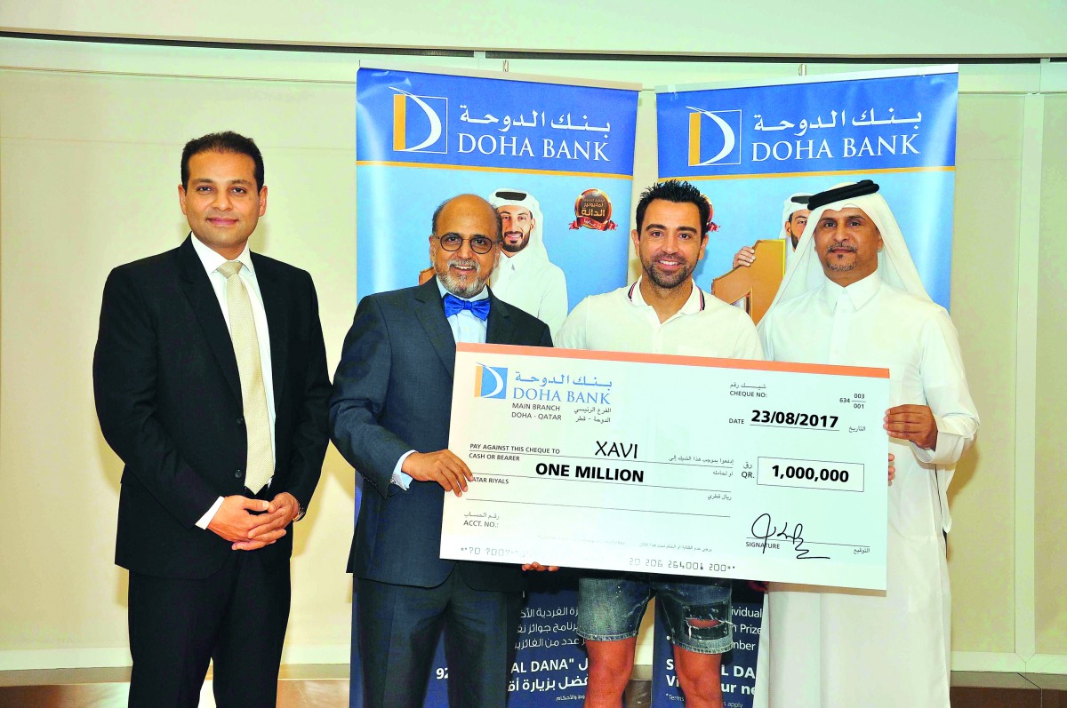 Dr R Seetharaman (second left), CEO of Doha Bank, handing over the QR1m prize ceremonial cheque to Xavier ‘Xavi’ Hernandez Creus (second right), the winner of this year’s third Al Dana draw, at Doha Bank’s Mall of Qatar branch.