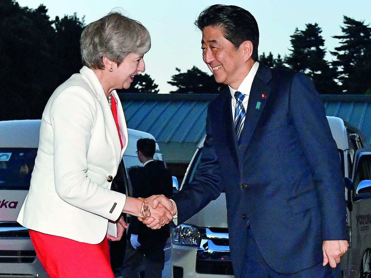 British Prime Minister Theresa May (left) is welcomed by Japanese Prime Minister Shinzo Abe upon her arrival for a Japan-UK dinner at the Kyoto State Guesthouse in Kyoto, yesterday. 