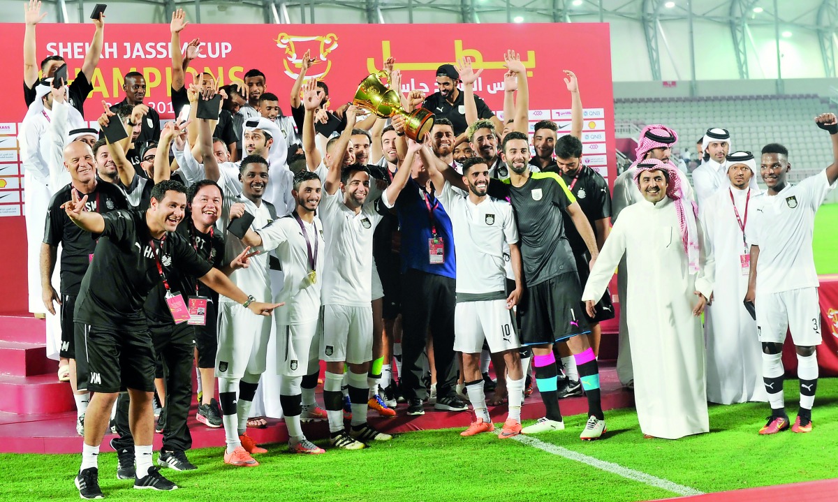 Al Sadd’s players and officials celebrate on the podium with the trophy after  winning the Sheikh Jassim Cup at Al Duhail Stadium yesterday. Picture: Kamutty VP