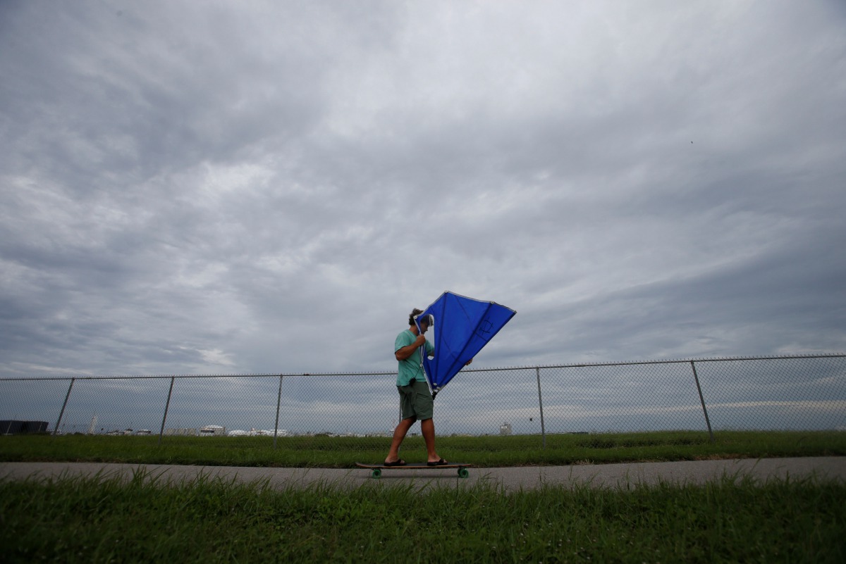 A man uses a kayak sail to propel himself on his skateboard ahead of the arrival of Hurricane Irma in Tampa, Florida, U.S., September 9, 2017. Reuters/Chris Wattie