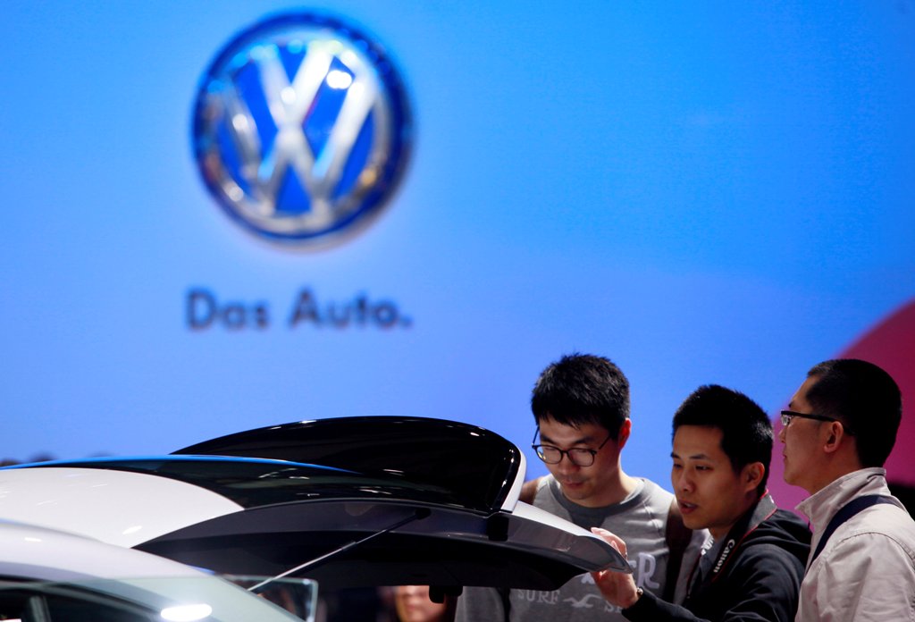 Guests look at a Volkswagen car during the media day at 15th Shanghai International Automobile Industry Exhibition in Shanghai April 20, 2013. REUTERS/Aly Song/File Photo
