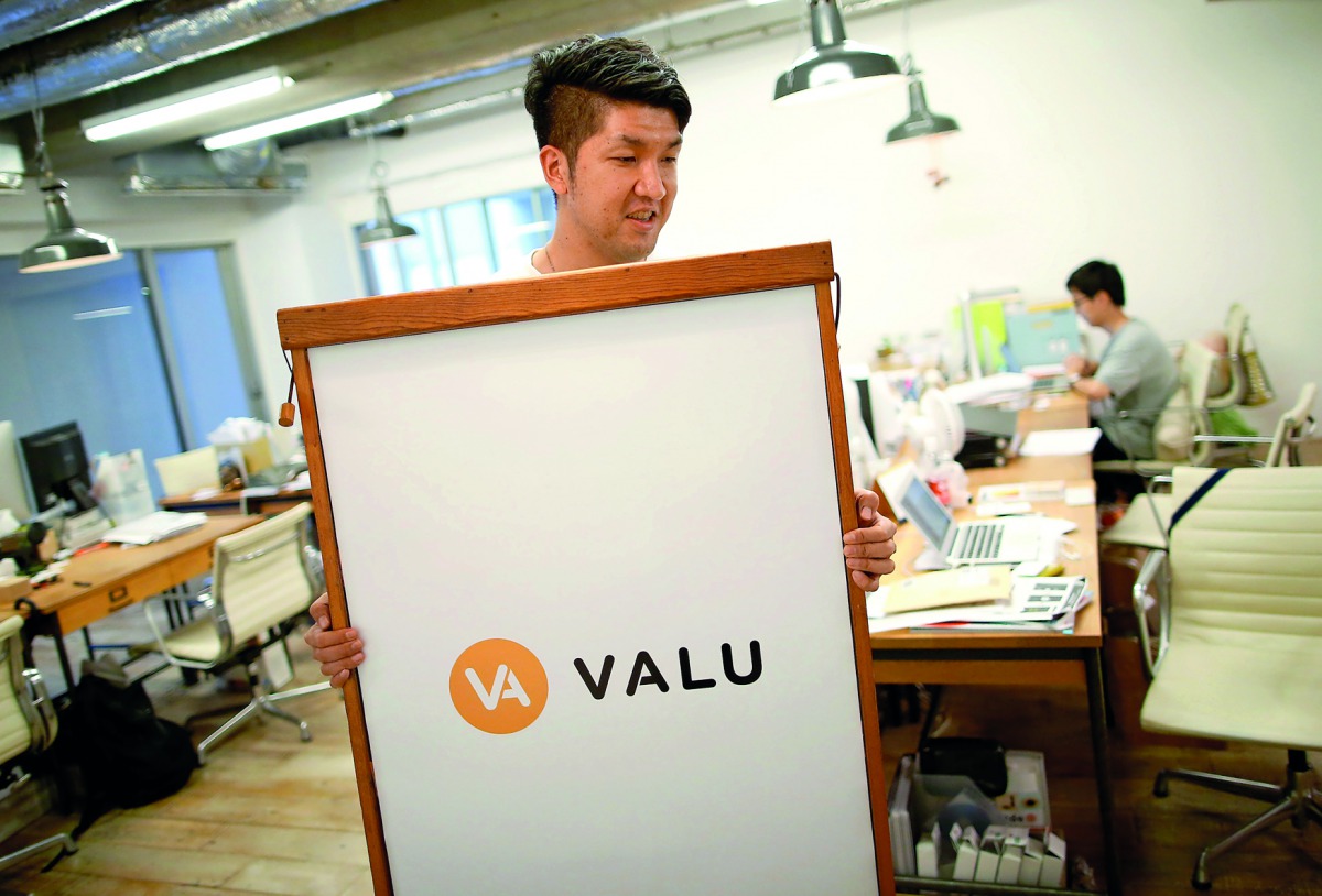 Employees work at the company office running Valu, a web-based virtual exchange in Tokyo, Japan.