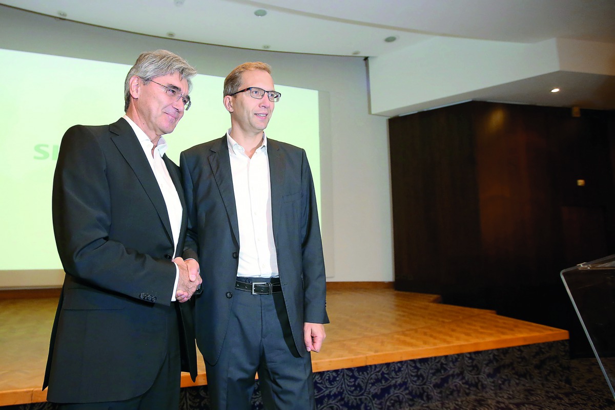 Henri Poupart-Lafarge, Chairman and Chief Executive Officer of Alstom, shakes hands with Siemens President and CEO Joe Kaeser (L) at a news conference to announce their deal to merge their rail operations, creating a European champion, in Paris, France, S