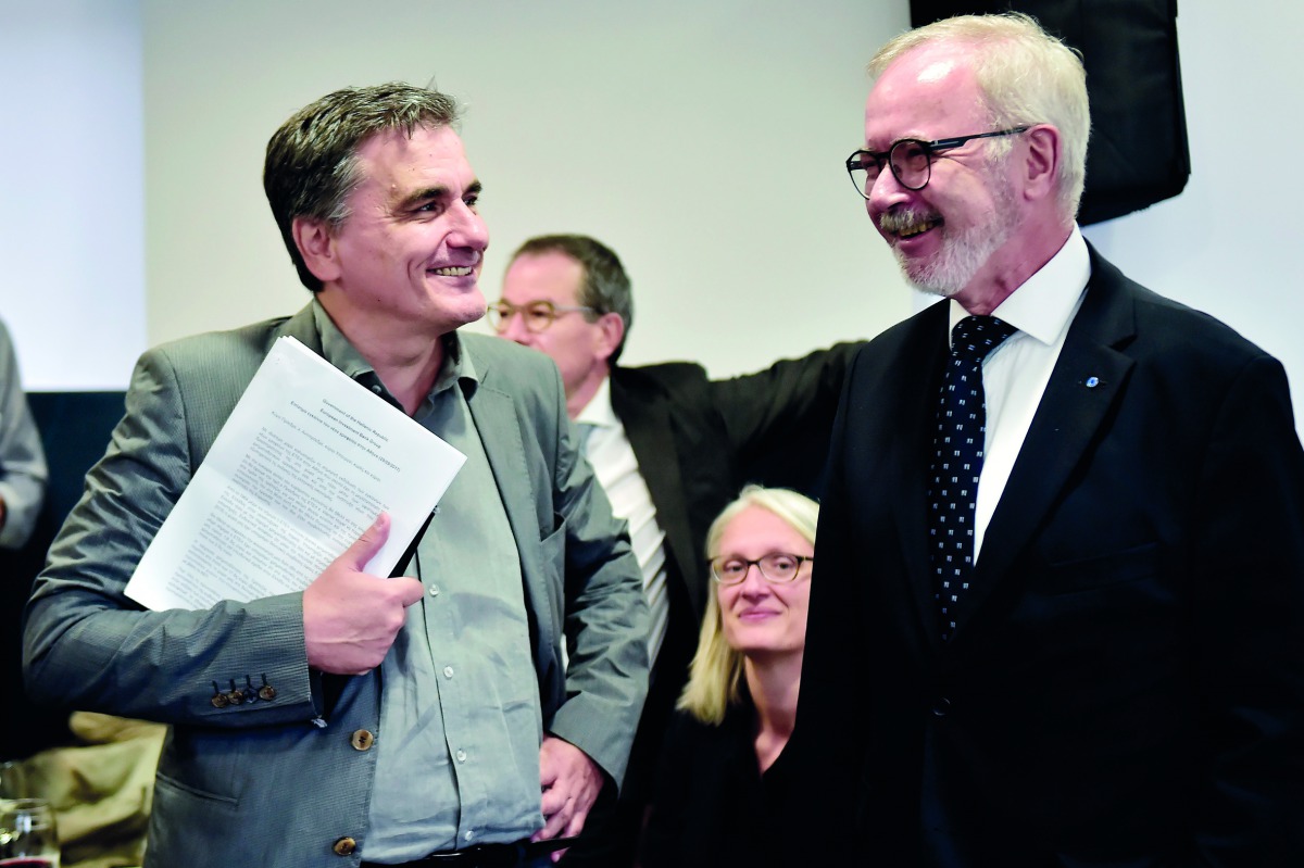 European Investment Bank (EIB) President Werner Hoyer (R) speaks with Greek finance minister, Euclid Tsakalotos during the inauguration of the EIB offices in Athens on September 29, 2017. AFP / Louisa Gouliamaki