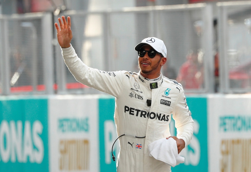 Mercedes’ Lewis Hamilton waves after getting pole position in qualifying. REUTERS/Edgar Su
