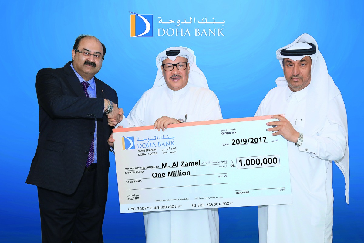 Doha Bank officials present a symbolic cheque for the Dana Millionaire winner. 