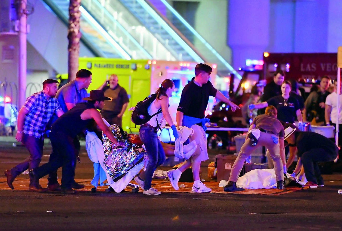 An injured person is tended to at the site of the shooting at a country music festival in Las Vegas, Nevada, yesterday.