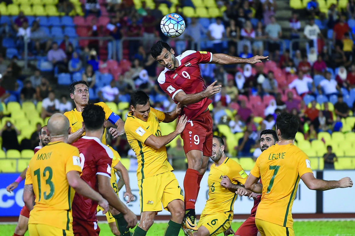 Omar Al Somah of Syria (centre) heads the ball during the 2018 World Cup qualifier against Australia at the Hang Jebat Stadium in Malacca  yesterday. Al Soma scored through a late penalty as Syria drew 1-1 with Australia to put their two-legged World Cup 