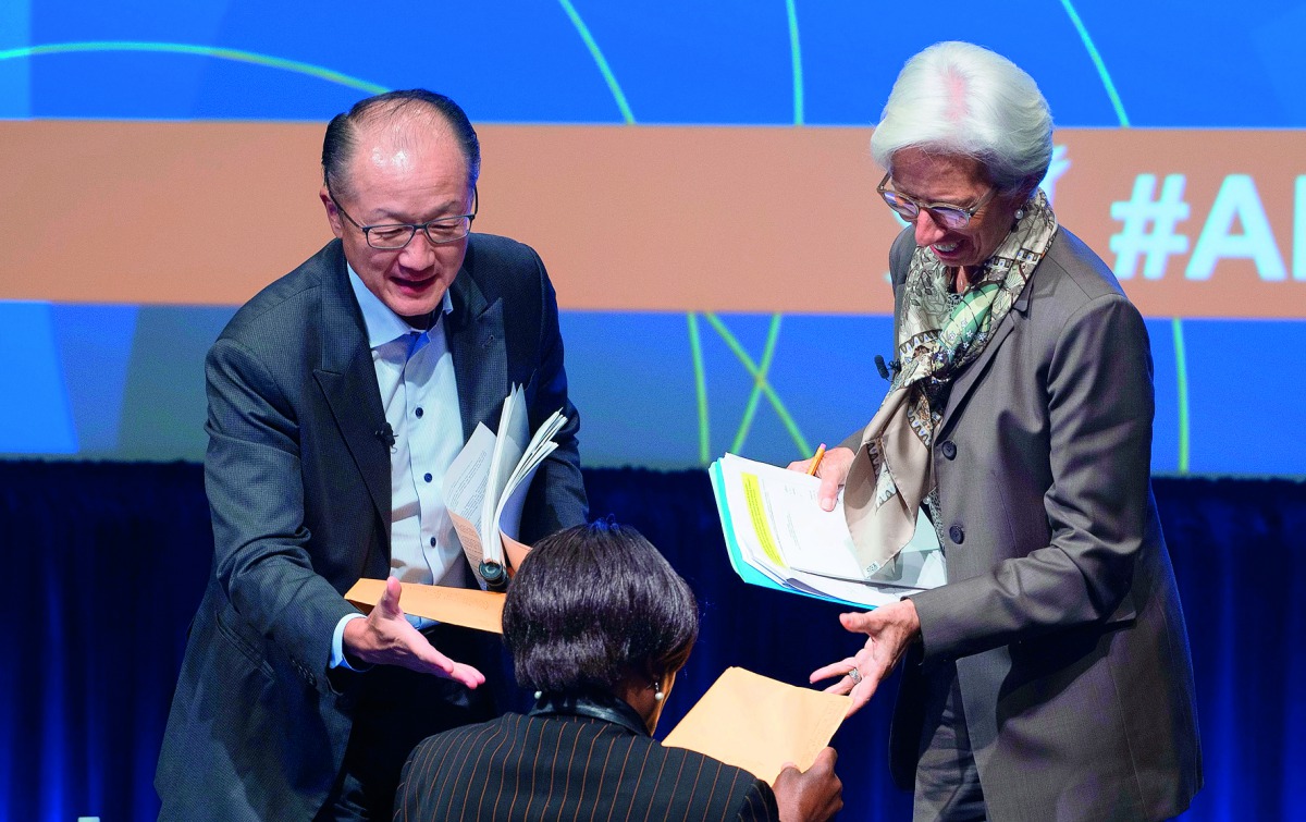 IMF Managing Director Christine Lagarde (right) and World Bank President Jim Yong Kim, take a folder of questions from a participant at a CSO Townhall at the World Bank headquarters in Washington DC.