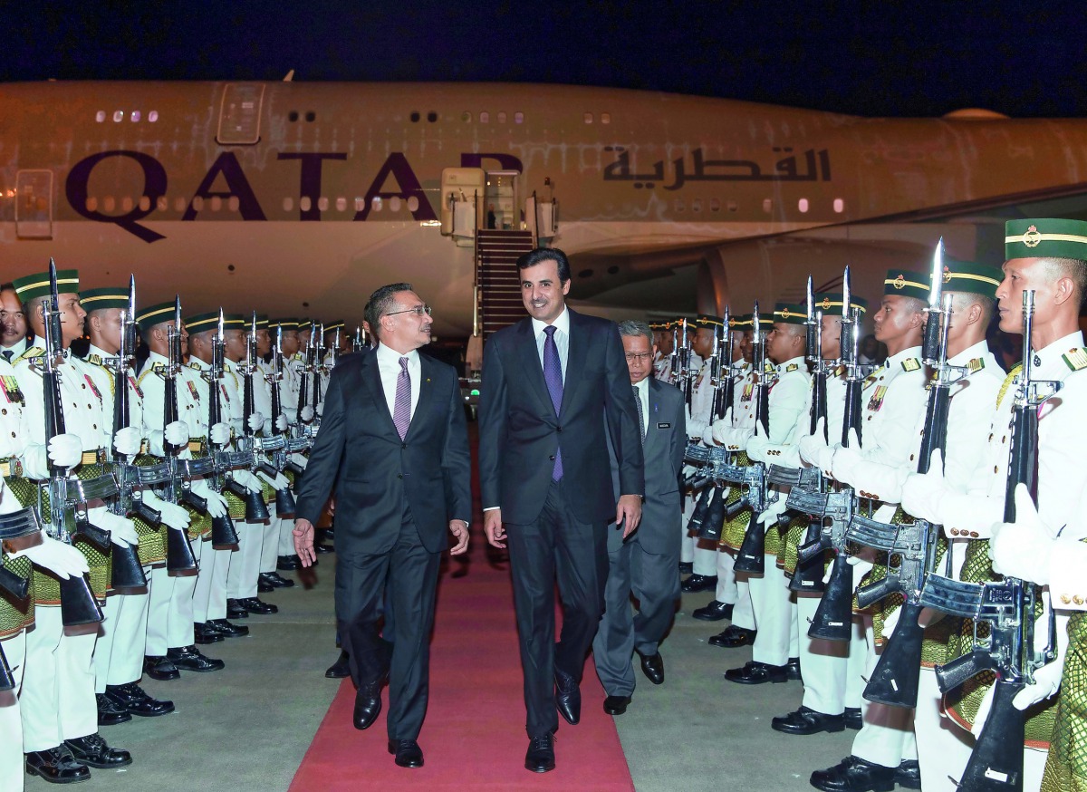Emir H H Sheikh Tamim bin Hamad Al Thani is received at the Kuala Lumpur International Airport by Malaysia’s Minister of Defence Hishammuddin Hussein, yesterday. 