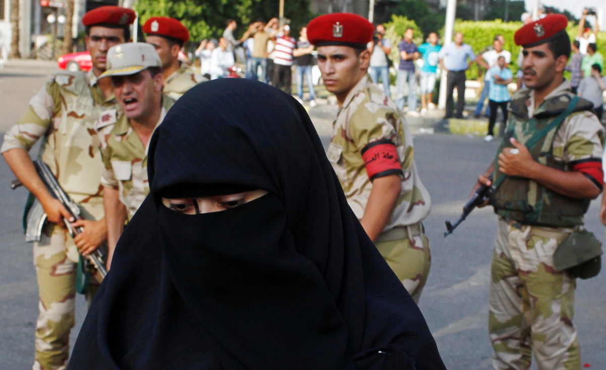 Army soldiers ask a female supporter of overthrown President Mohamed Mursi to take her protest to the sidewalk as they stand guard around Cairo University and Nahdet Misr Square in Giza, on the outskirts of Cairo, July 4, 2013. Reuters/ Asmaa Waguih
