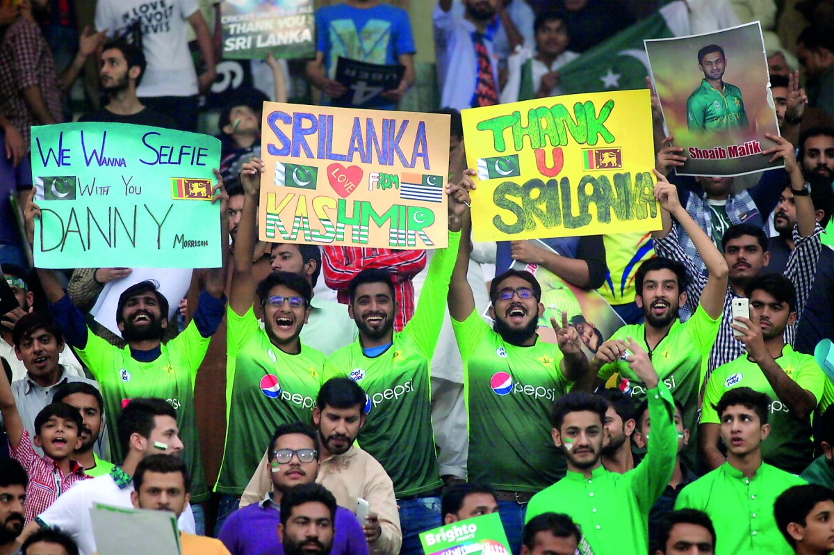 Spectators hold placards during the Twenty20 international between Pakistan and Sri Lanka in Lahore, yesterday. 