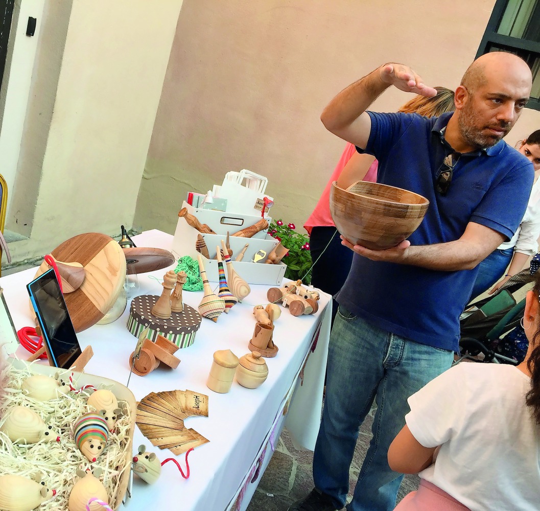 Joseph Gereige, a woodturner, shows some of the wooden objects he made at the QatART Hand-made Market at Katara Art Studios courtyard yesterday.  Pic: Raynald C Rivera / The Peninsula 