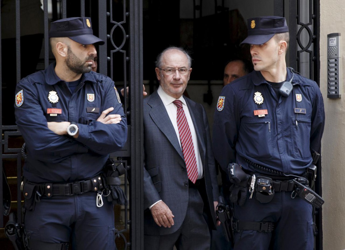 Former International Monetary Fund chief Rodrigo Rato (C) walks between police officers as he leaves his office in Madrid April 17, 2015. REUTERS/Andrea Comas