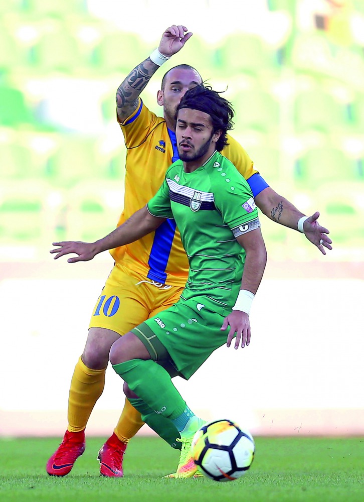 Al Gharafa’s Dutch midfielder Wesley Sneijder (in yellow) is challenged by a Al Ahli player during the QNB Stars League match at the Al Ahli Stadium in Doha yesterday.