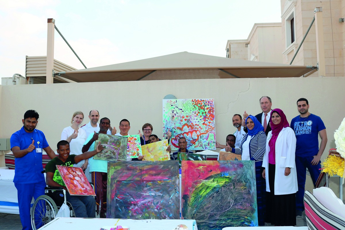 Patients and healthcare professionals with the artwork illustrated during the ‘Qatar Cares’ event to be displayed at the Bayt Aman residential villa in Al Thumama.