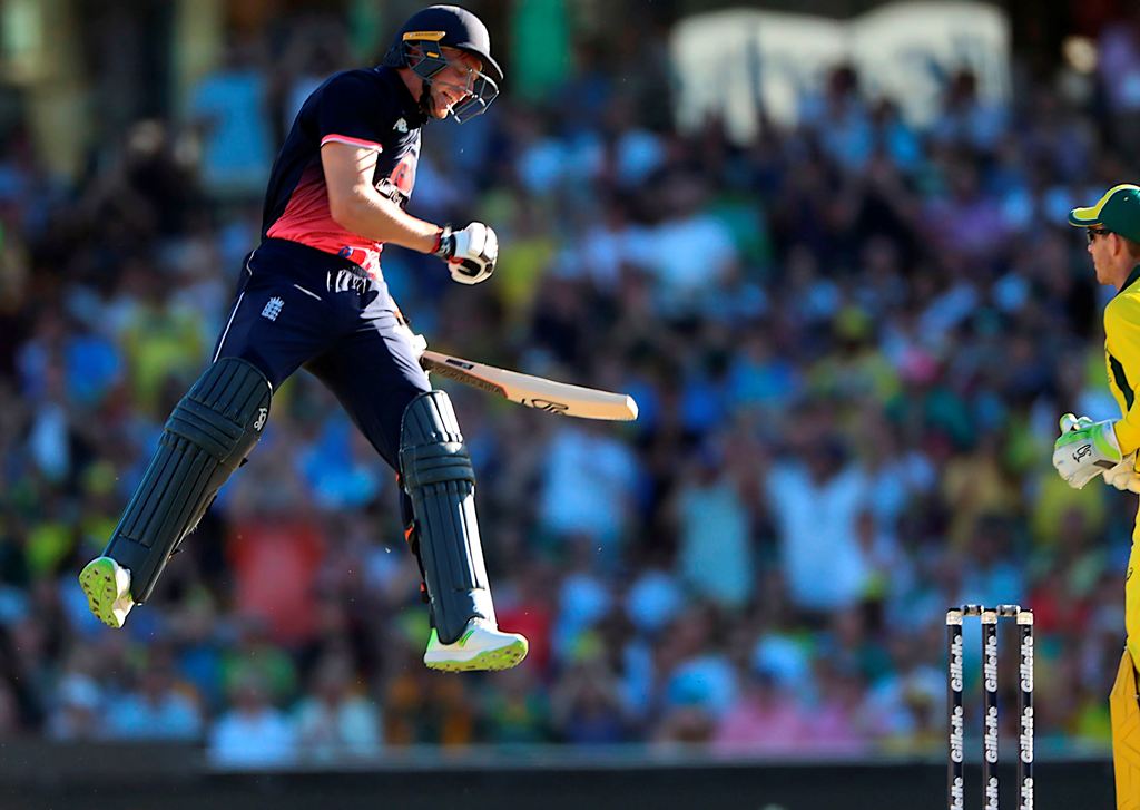 England batsman Jos Buttler jumps for joy as he reaches his century during the third one-day international (ODI) cricket match between England and Australia in Sydney on January 21, 2018.  (AFP / Glenn Nicholls )