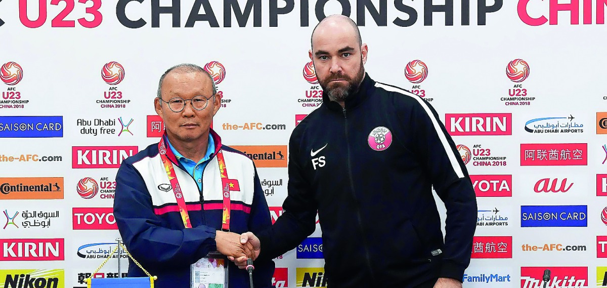 Qatar coach Felix Sanchez shakes hands with Vietnam coach Park Hang-seo during a pre-match press conference held in Changzhou, China yesterday. 