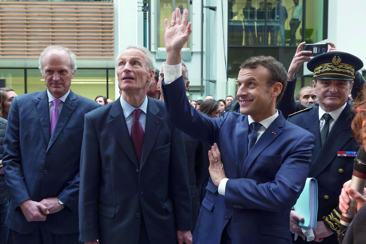 French President Emmanuel Macron waves as he stands next to Michelin group chairman Jean-Dominique Senard during a visit at the Michelin Ladoux Research and Technology centre in Ladoux, France, January 25, 2018. Reuters/Thierry Zoccolan