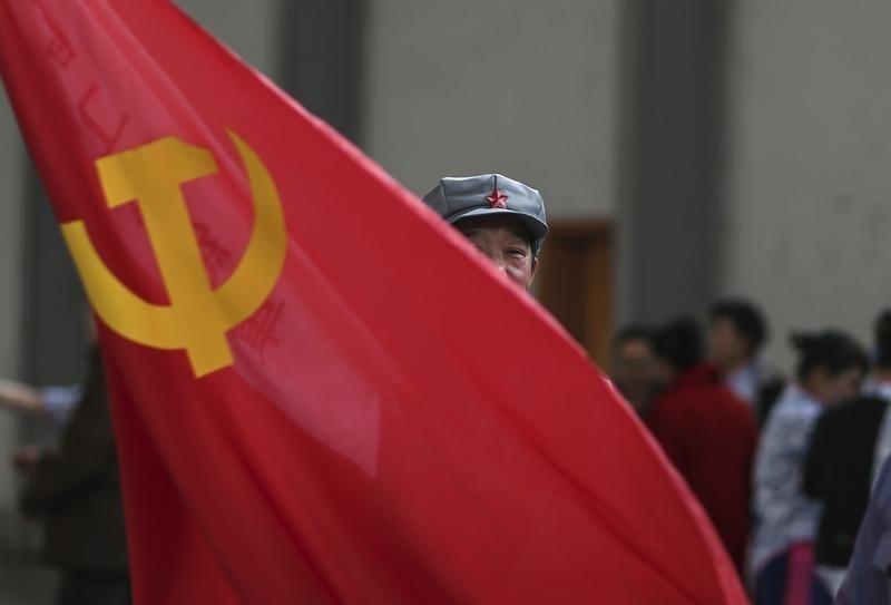 A participant waves a Chinese Communist Party flag as he waits backstage before his performance at a line dancing competition in Kunming Yunnan province, January 31, 2015 (Reuters) 