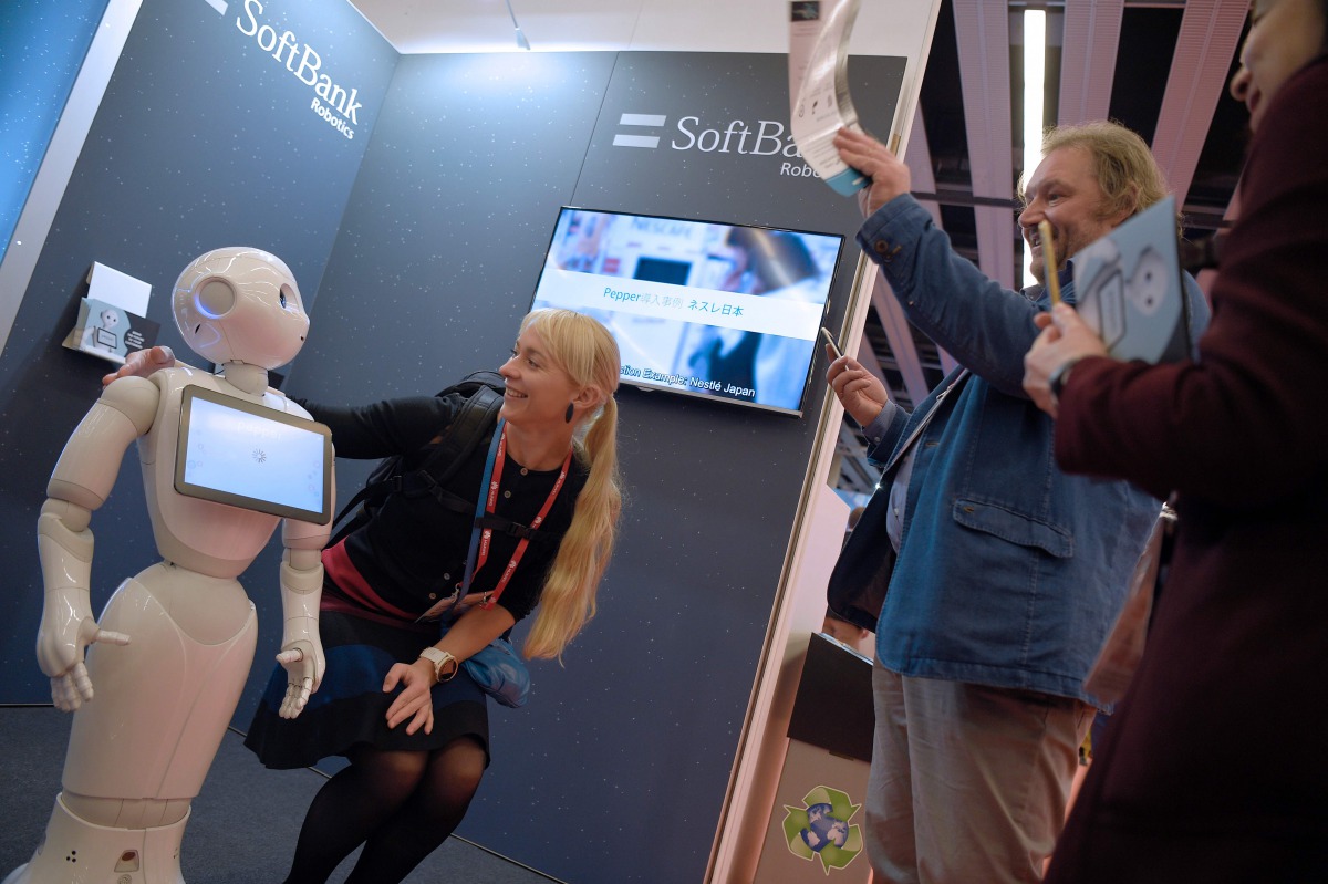 Pepper interacts with visitors at the SoftBank Robotics stand on the first day of the Mobile World Congress in Barcelonaon on February 27, 2017 in Barcelona (AFP / Lluis Gene) 
