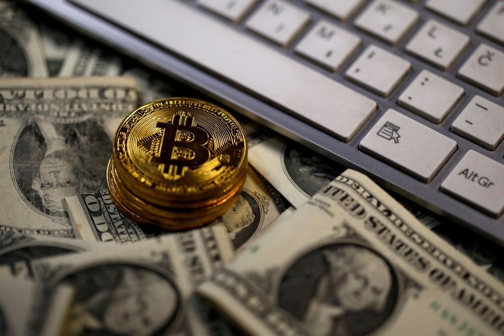 Bitcoin (virtual currency) coins placed on Dollar banknotes, next to computer keyboard, are seen in this illustration picture, November 6, 2017. REUTERS/Dado Ruvic/Illustration/File Photo
