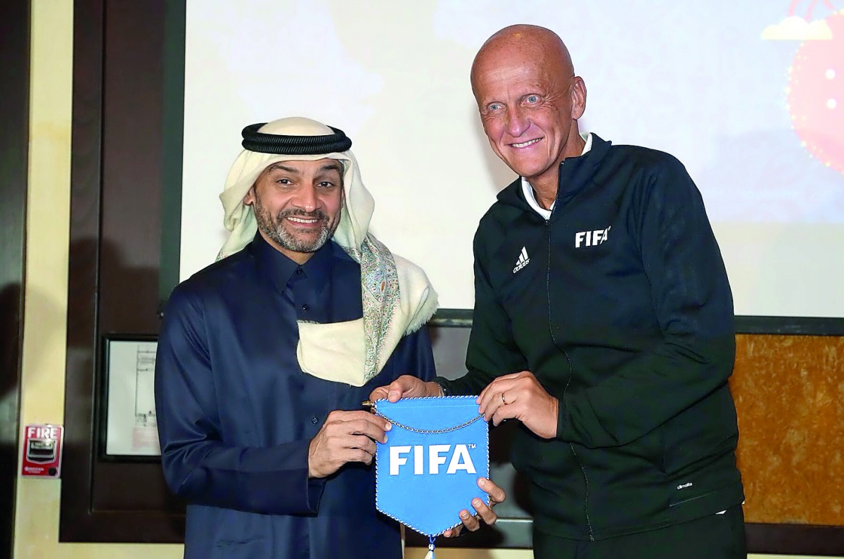 Former Italian referee Pierluigi Collina (right) presents a souvenir to Hani Balan, Chairman of the Qatar Referees Committee and Vice-Chairman of the FIFA Referees Committee on Monday.