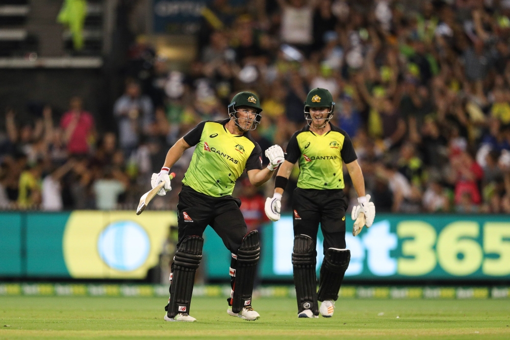 Australia's Aaron Finch (L) celebrates the Aussies 3rd series win with D'Arcy Short (R) during the Twenty20 International Tri-Series cricket match between England and Australia at the MCG in Melbourne on February 10, 2018. AFP / CON CHRONIS 