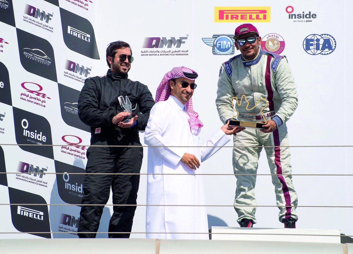 Podium winners at the Fourth Round of Qatar Touring Car Championship receiving  their prizes from an official at Losail International Circuit on Saturday.