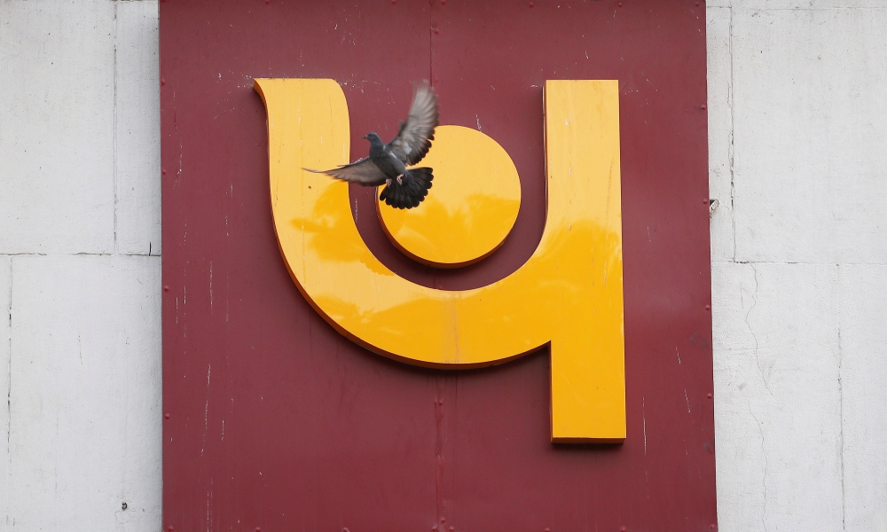 A pigeon flies past the logo of Punjab National Bank outside a branch of the bank in New Delhi, India February 15, 2018. Reuters/Adnan Abidi