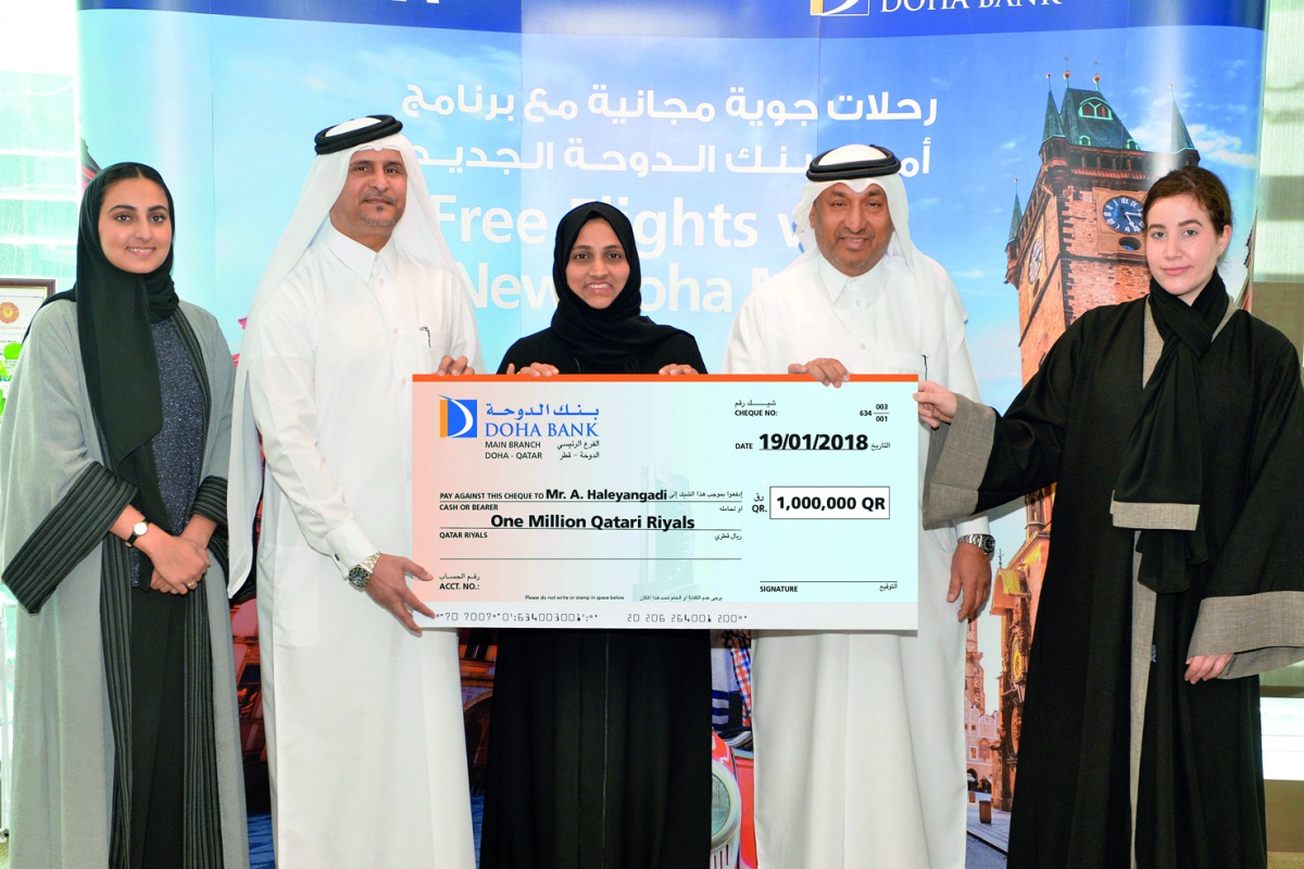 Doha Bank officials giving away a symbolic cheque for the Al Dana Saving Scheme’s QR1m  winner.